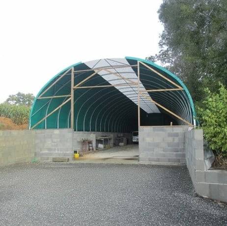 Plastidis - Abri tunnel largeur 9.30 m pas à 1.50 m - Long 19.50 m, type Camion 640 gr/m² gris clair, Façade 1 porte souple et 1 façade pleine - Image 9